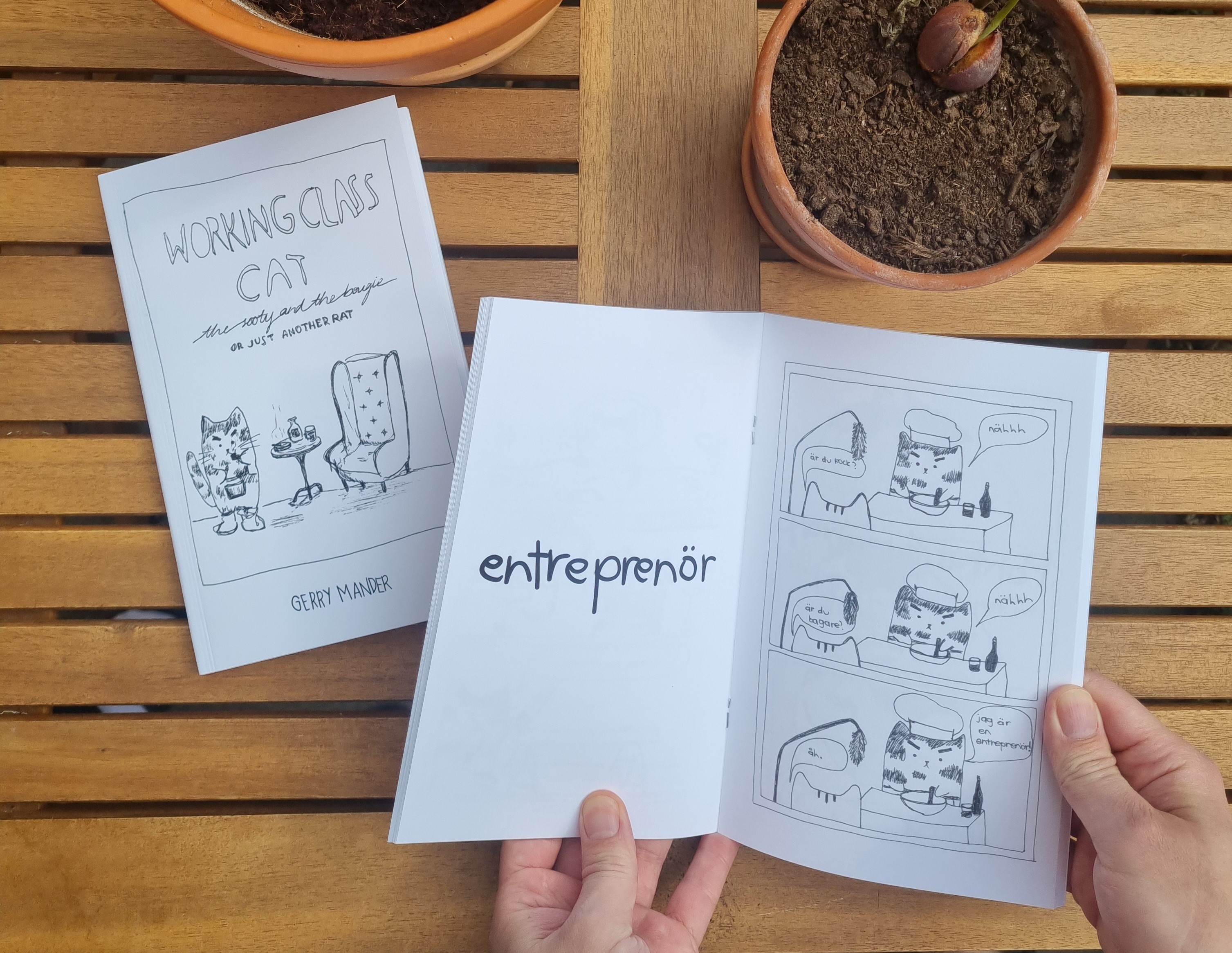 An opened page of the zine, Working Class Cat, showing a comic strip about entrepreneurship.